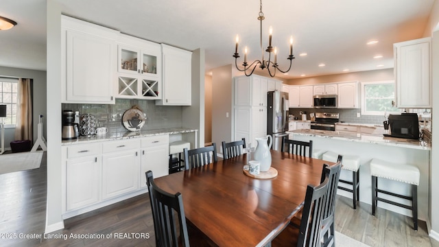 dining room featuring dark wood finished floors, a wealth of natural light, and recessed lighting