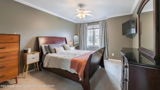 bedroom featuring ornamental molding, light colored carpet, baseboards, and a ceiling fan