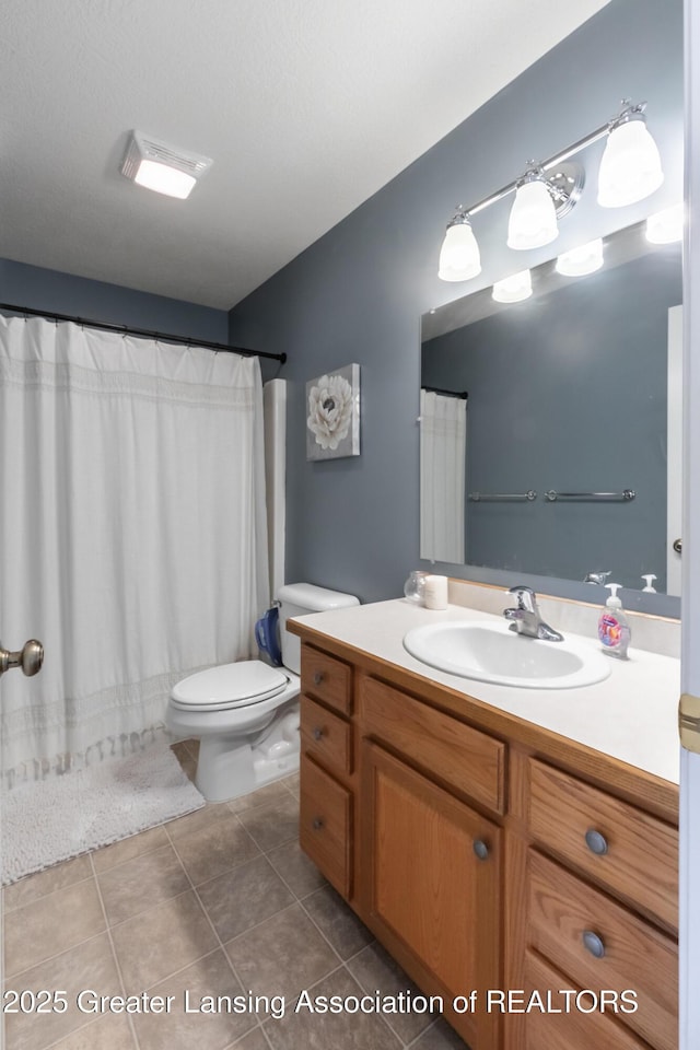 bathroom featuring curtained shower, vanity, toilet, and tile patterned floors