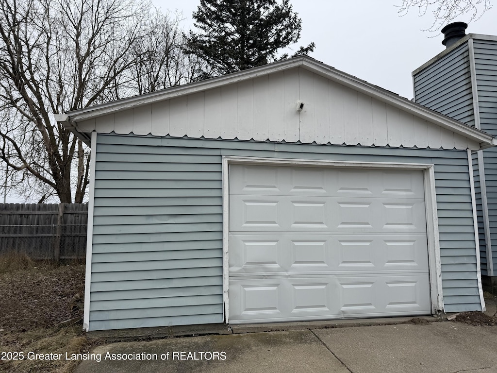 detached garage featuring fence