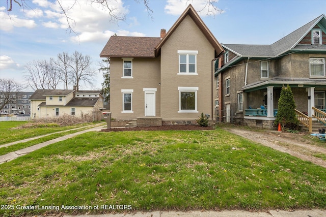 909 W Ionia St, Lansing, MI 48915 - view of front of house with a chimney, covered porch, a front lawn, and brick siding