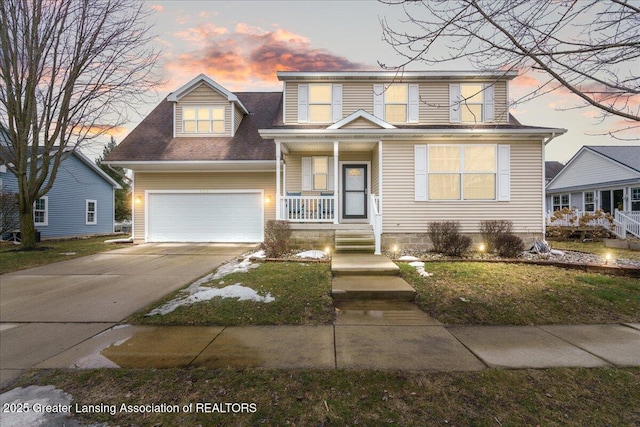 traditional home featuring covered porch, concrete driveway, and a garage