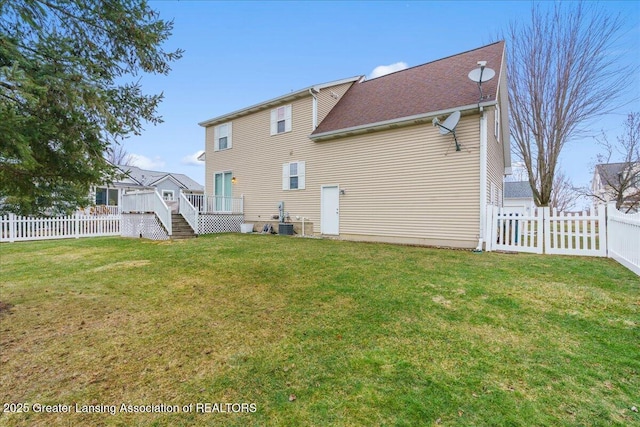 back of property featuring a lawn, a fenced backyard, and a wooden deck