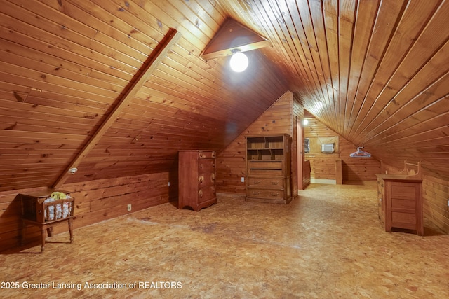 additional living space with lofted ceiling, wood walls, and wooden ceiling