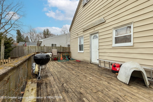 wooden deck with a grill and fence