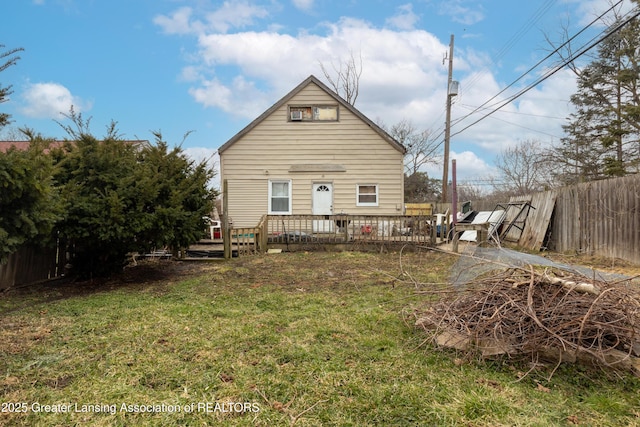 back of house featuring a deck, a lawn, and fence