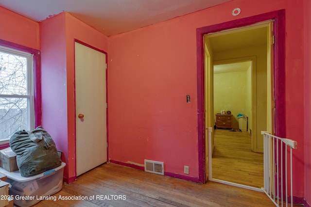 unfurnished room featuring visible vents and hardwood / wood-style floors