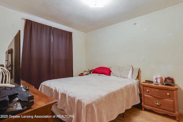 bedroom featuring a textured ceiling and wood finished floors