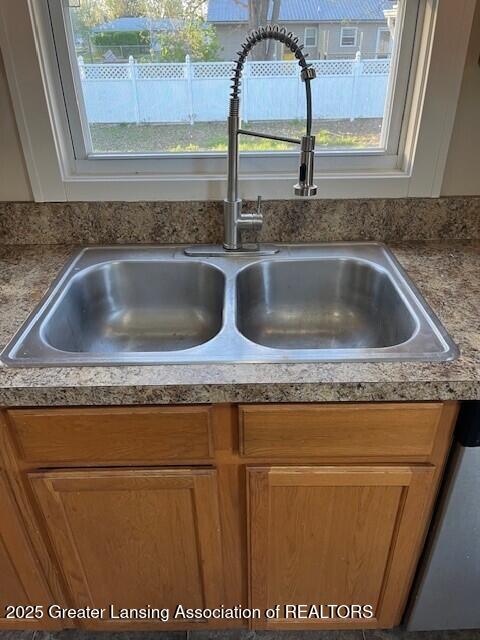 room details with a sink, dishwasher, and light countertops