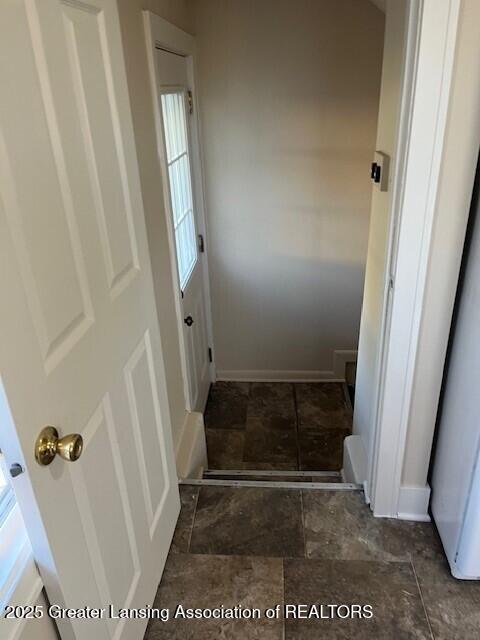 interior space with a healthy amount of sunlight, baseboards, and stone finish flooring