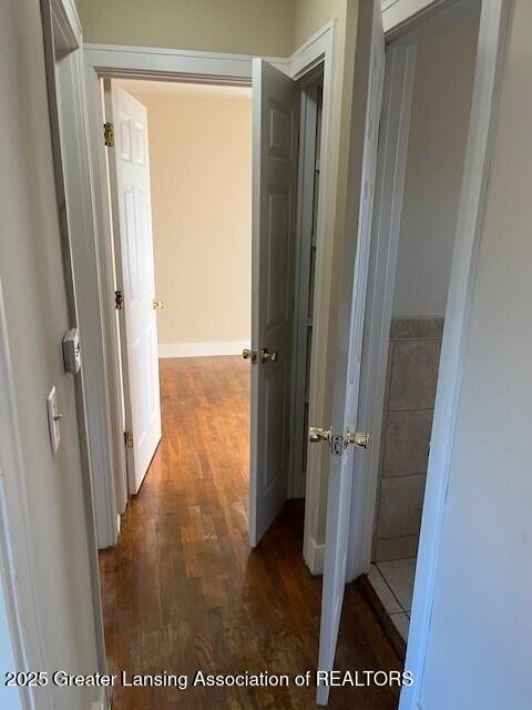 hall featuring baseboards and wood finished floors