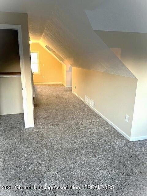 bonus room with baseboards, vaulted ceiling, and carpet floors