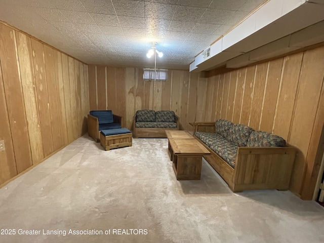 sitting room with carpet floors and wood walls