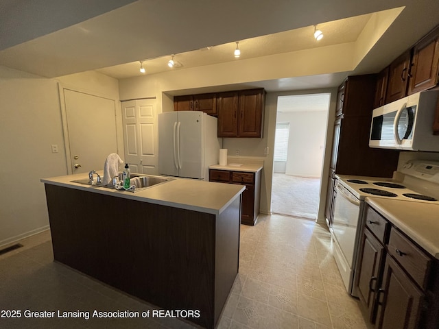 kitchen with light countertops, white appliances, a sink, and dark brown cabinetry