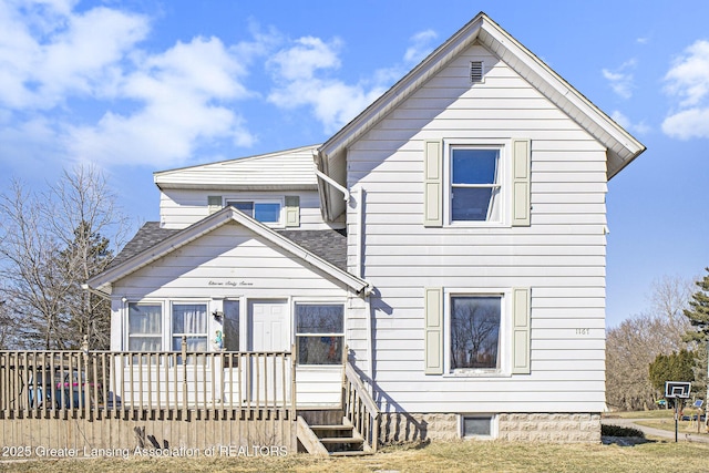 view of front of home with roof with shingles and a wooden deck