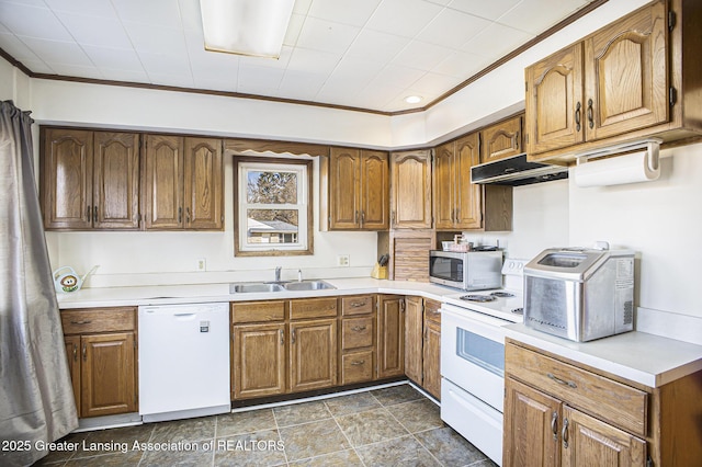 kitchen featuring white appliances, brown cabinetry, a sink, and under cabinet range hood