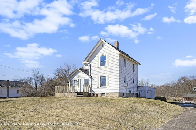 view of front of property featuring a deck, a front yard, and a chimney