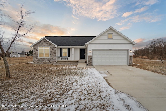 single story home with driveway, stone siding, a garage, and board and batten siding