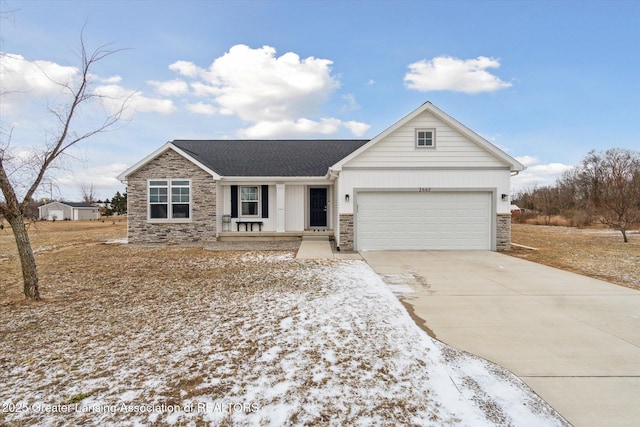 view of front of home featuring an attached garage, concrete driveway, a porch, and stone siding