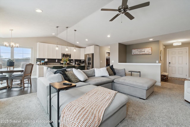 living room with lofted ceiling, ceiling fan with notable chandelier, and recessed lighting