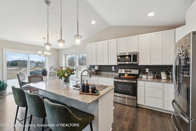 kitchen with lofted ceiling, dark wood-style flooring, a sink, stainless steel appliances, and backsplash