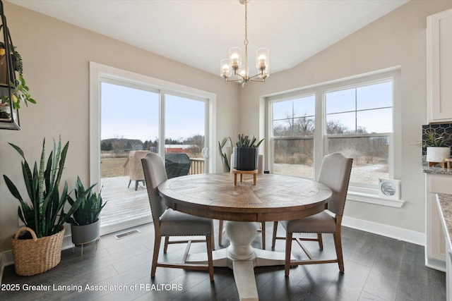 dining space featuring lofted ceiling, visible vents, dark wood-type flooring, a chandelier, and baseboards