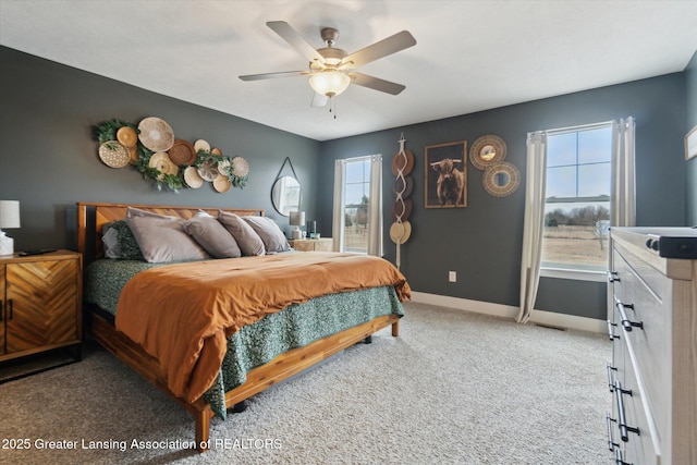 carpeted bedroom with ceiling fan and baseboards