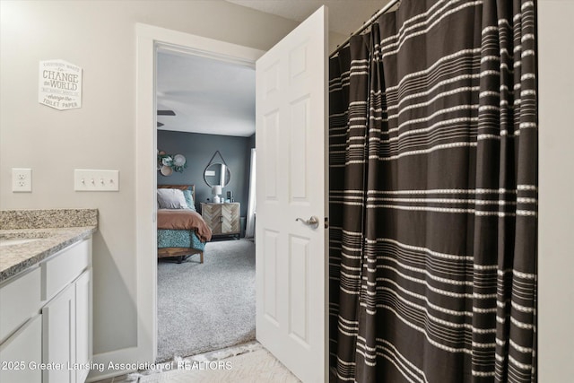 ensuite bathroom with a shower with shower curtain, connected bathroom, and vanity