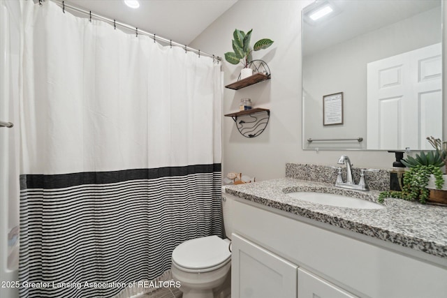 full bath with toilet, a shower with shower curtain, and vanity