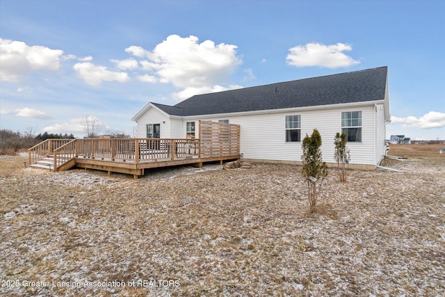 rear view of house featuring a shingled roof and a deck