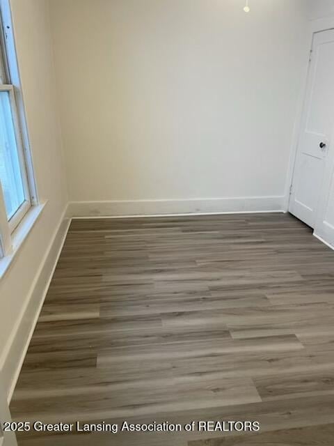 empty room featuring baseboards and wood finished floors