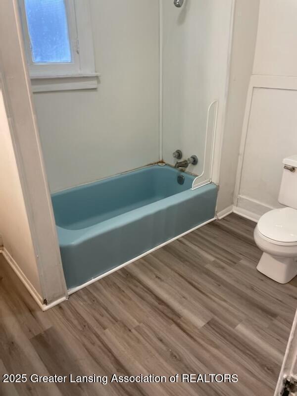 full bathroom with toilet, wood finished floors, and shower / bath combination