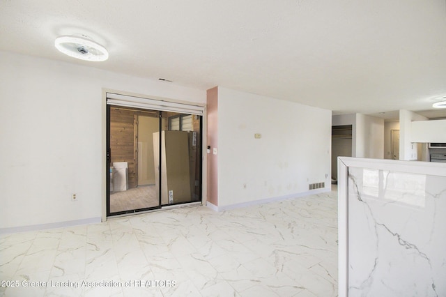 spare room with visible vents, marble finish floor, and baseboards