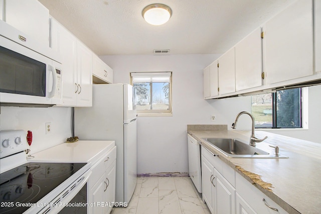 kitchen featuring white appliances, a sink, light countertops, white cabinetry, and marble finish floor