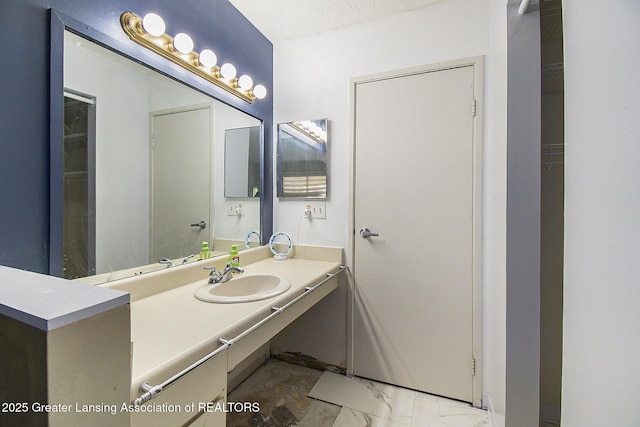 bathroom with marble finish floor and vanity