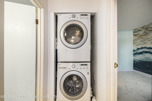 laundry area with stacked washer and clothes dryer, baseboards, marble finish floor, and laundry area