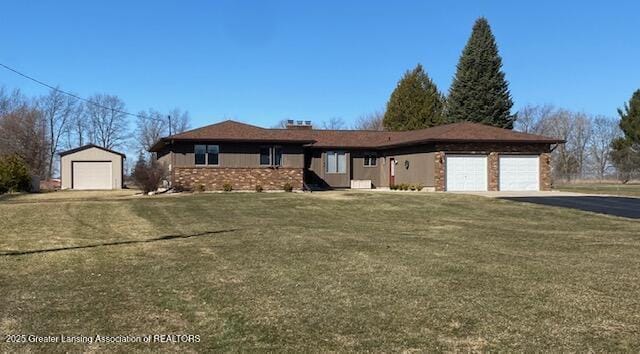 view of front of property featuring a garage, driveway, brick siding, and a front yard