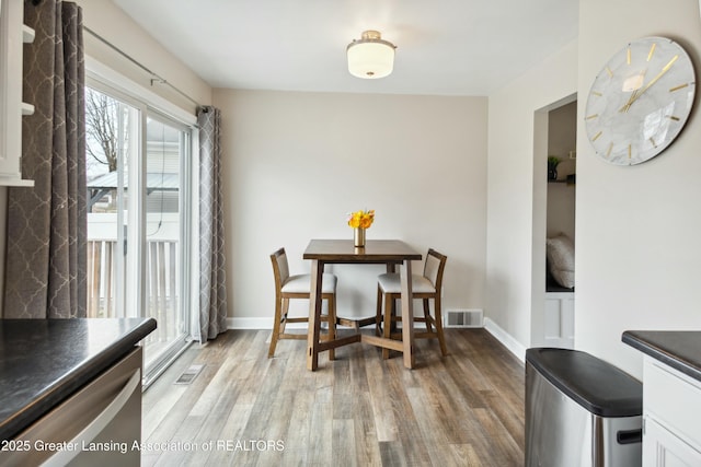 dining space featuring visible vents, baseboards, and light wood-style flooring