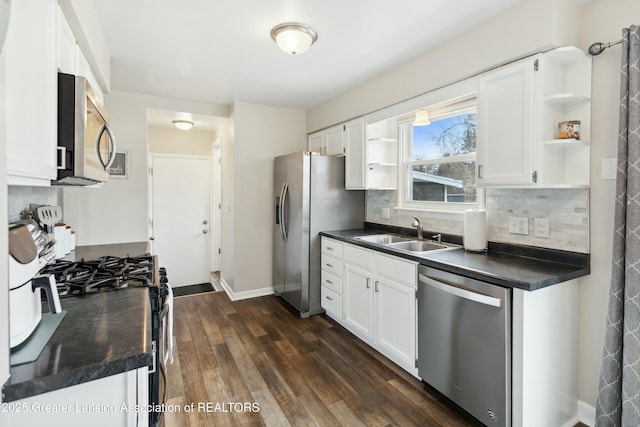 kitchen with open shelves, dark countertops, appliances with stainless steel finishes, and a sink