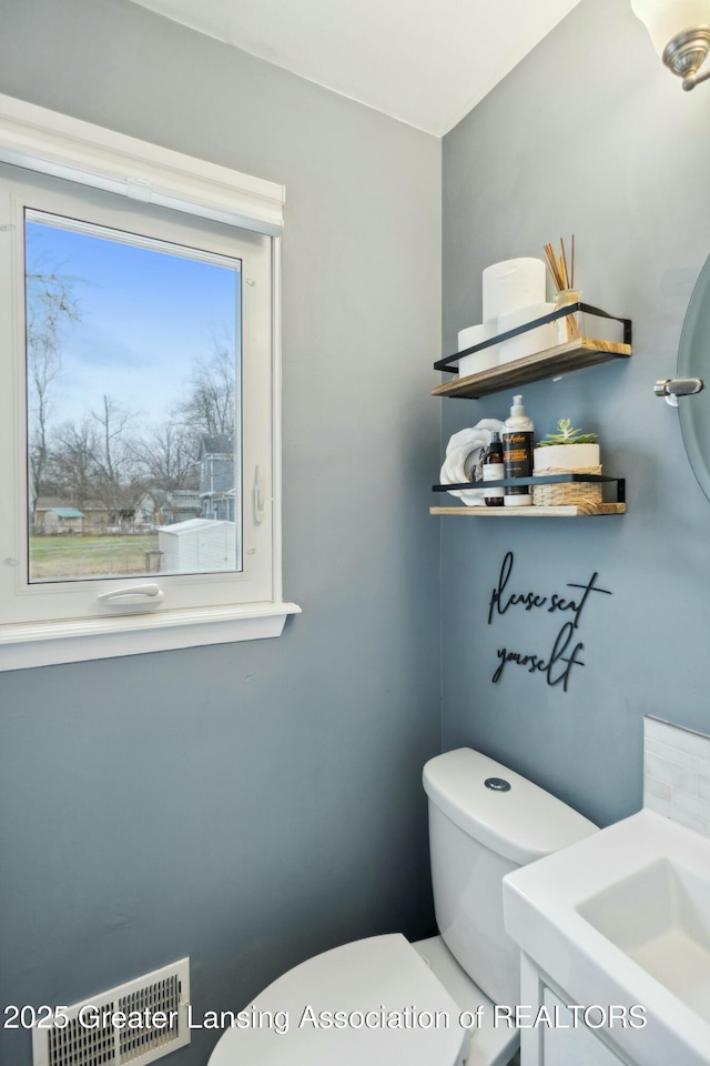 bathroom featuring visible vents and toilet