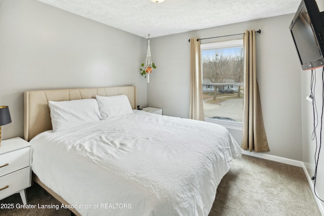 carpeted bedroom featuring baseboards and a textured ceiling