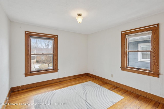 empty room with baseboards and light wood-style floors