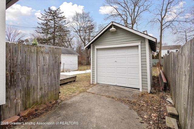 detached garage with driveway and fence