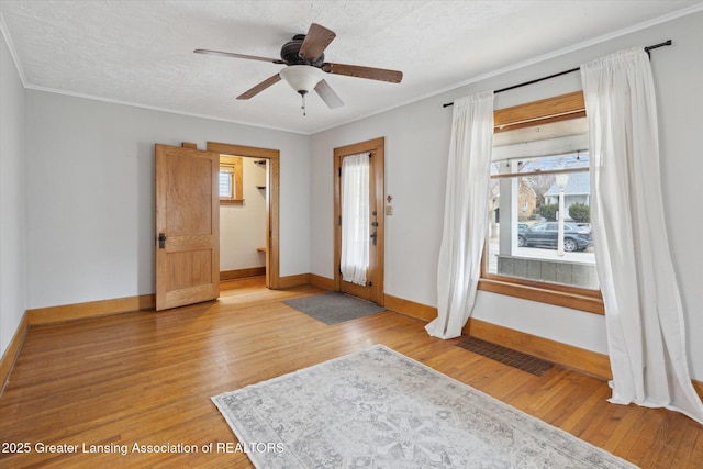 entryway featuring visible vents, light wood-style flooring, and ornamental molding