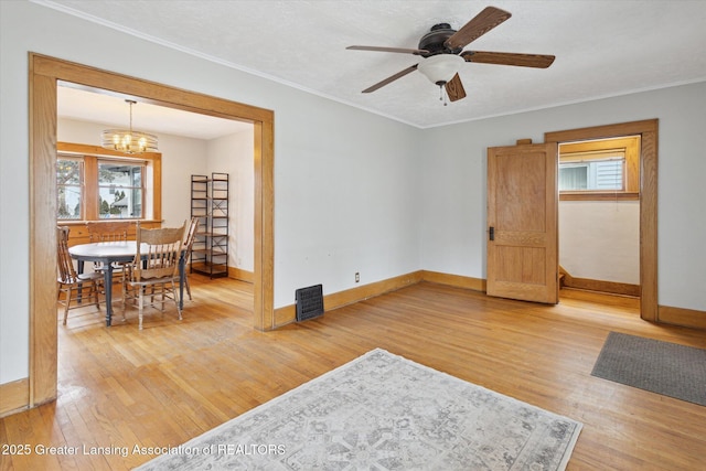 interior space featuring baseboards, light wood-style floors, and ornamental molding