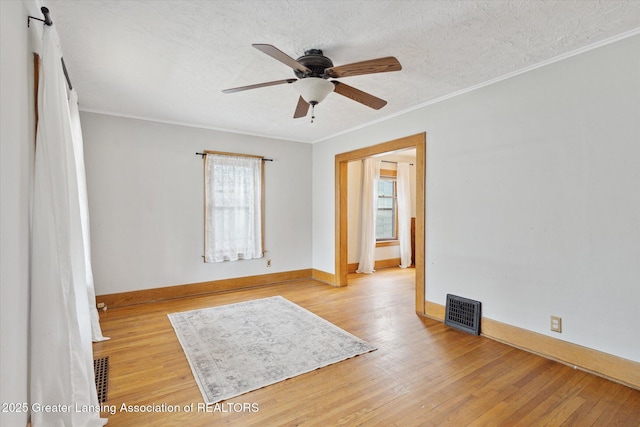 unfurnished room with visible vents, light wood-style floors, and a textured ceiling