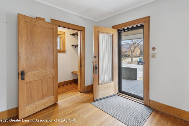 doorway to outside featuring light wood-type flooring, baseboards, and ornamental molding