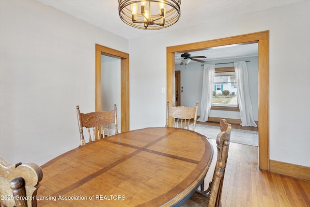 dining room with baseboards, an inviting chandelier, and hardwood / wood-style flooring