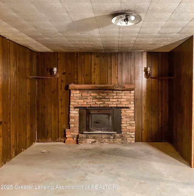 unfurnished living room featuring unfinished concrete flooring and wooden walls