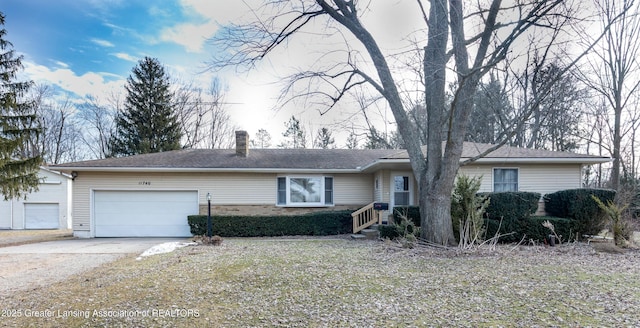 ranch-style house featuring a chimney, an attached garage, concrete driveway, and brick siding